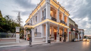 Un bâtiment historique doté d’une entrée imposante, de colonnes et d’un balcon.