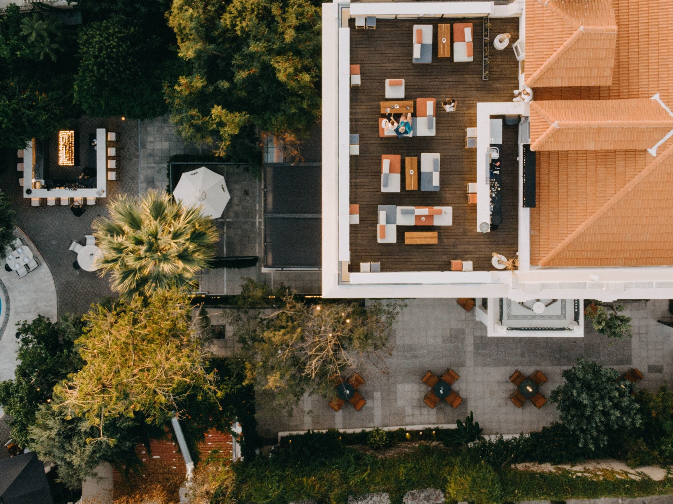 An aerial view of a rooftop lounge with outdoor seating and a pool area.