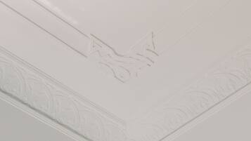 A white wall with a decorative molding and a subtle embossed design.