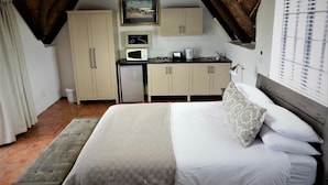 Habitació senzilla amb llit, petita cuina i finestra.