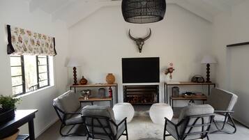 A living room with a fireplace, two rocking chairs, a ceiling fan, and a mounted bull's head.