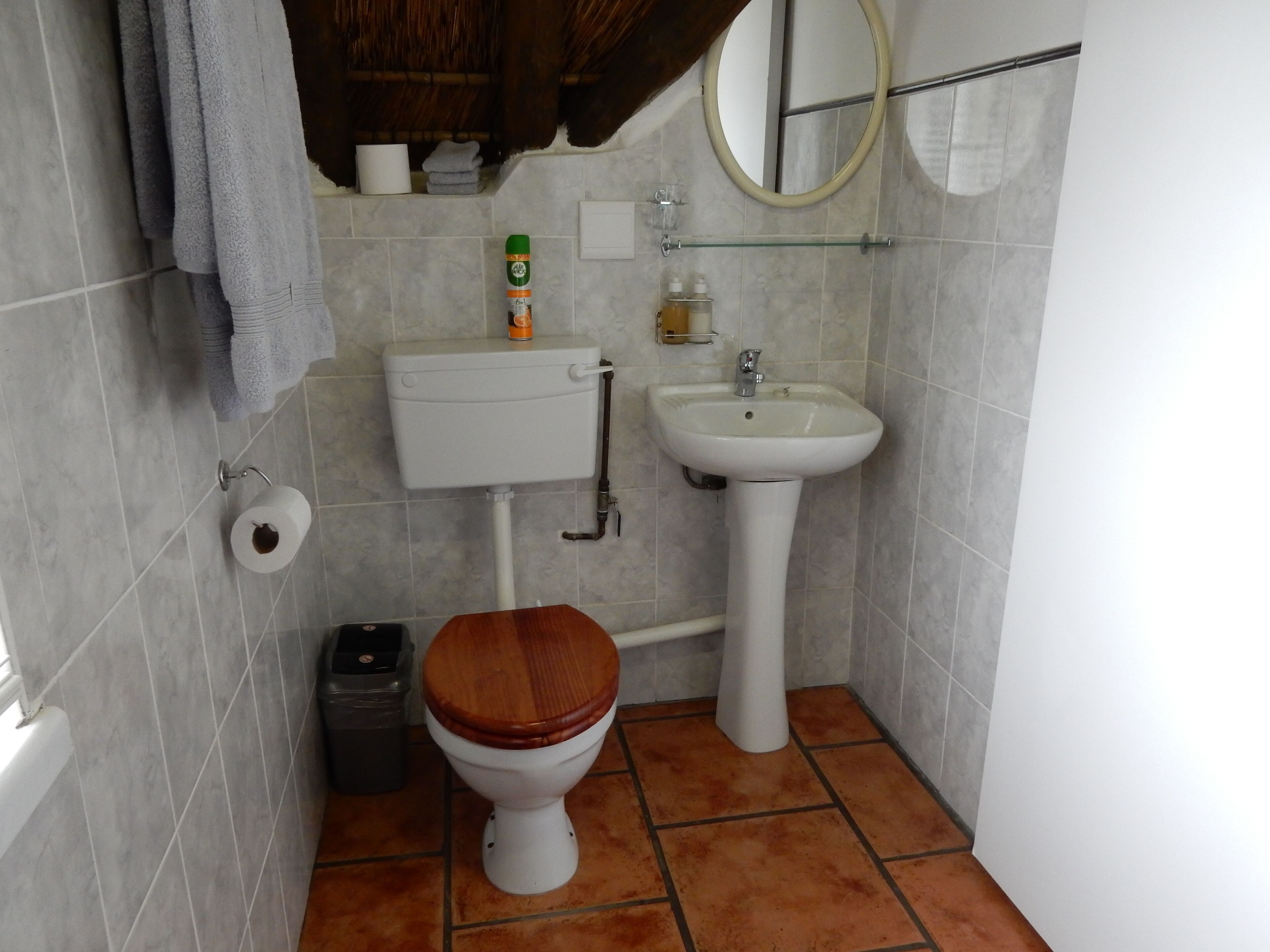 Ein kleines Badezimmer mit Toilette, Waschbecken und Spiegel.