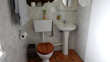 Ein kleines Badezimmer mit Toilette, Waschbecken und Spiegel.