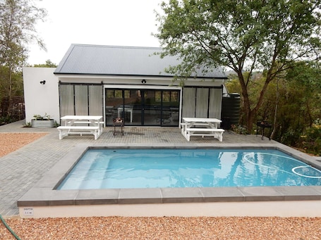 Una piscina al aire libre, sillones reclinables de piscina