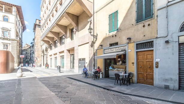 A narrow cobblestone street with a row of outdoor seating at a gelateria. - Wine Apartments Florence Franciacorta (Florence)