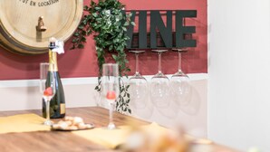 A wooden table with a bottle of champagne, glasses, and a decorative plant. - Wine Apartments Florence Franciacorta (Florence)