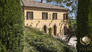 A traditional villa with a tiled roof, arched windows, and a well-maintained garden. - Villa San Marco (Fratte Rosa)