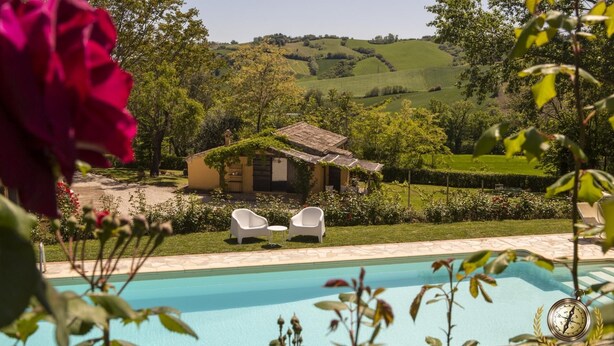 A pool area with a view of a countryside landscape, a small house, and two white chairs. - Villa San Marco (Fratte Rosa)