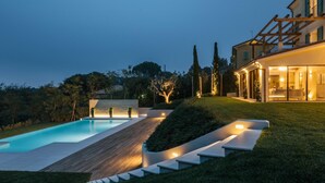 A modern house with a swimming pool, a wooden deck, and a well-lit interior. - Villa Sogno Adriatico (Civitanova Marche)