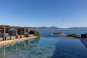 An infinity pool with a clear view of the sea and distant mountains. - Villa Kirssis (Pietrosella)