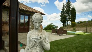 A stone statue in a courtyard with a building in the background. - Villa Panorama (Monte Santa Maria Tiberina)