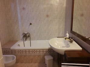 A bathroom with a bathtub, a sink, and a toilet.