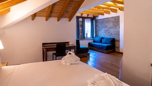Un dormitorio con una cama grande, un escritorio y un sofá azul.