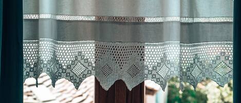 A window with a lace curtain and a wooden door.