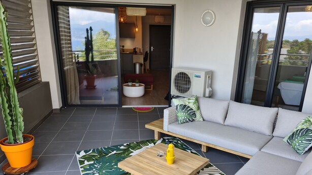 A modern living room with a sofa, a coffee table, and a potted plant. - Magnificent T2 parahotelier with 23m2 south-facing terrace and sea view (Ajaccio)