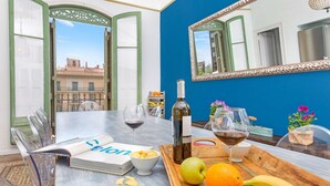A dining table with a book, wine glasses, a bottle of wine, and fruit. - Luxury and design in Rambla Catalunya (Barcelona)