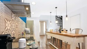 A modern kitchen with a central island, a built-in oven, and a patterned backsplash.