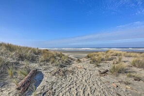 Una spiaggia sabbiosa con dune e una vista limpida sull'oceano.