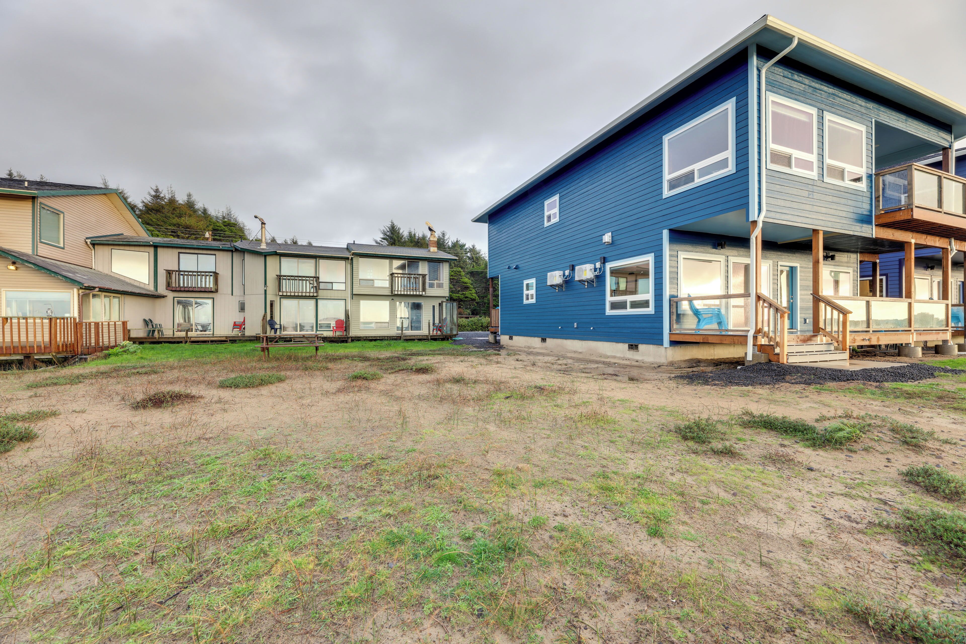 Una zona residencial con varias casas, incluyendo una casa azul con balcón y terraza de madera.