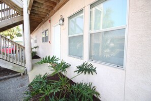 Guests can enjoy a peaceful porch with a railing and step leading up to the entrance.