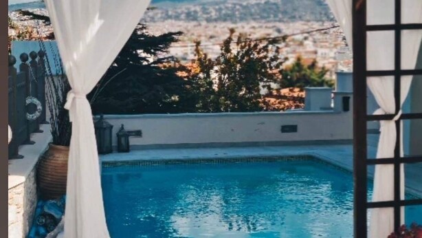 Una piscina con vistas a un paisaje urbano y montañas.