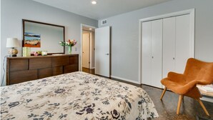 A bedroom with a bed, dresser, mirror, and a door leading to another room. - [SU 922 - 4] Graciela's Campus-close 2 bedroom luxury, Apartment near to Downtown Norman (Norman)