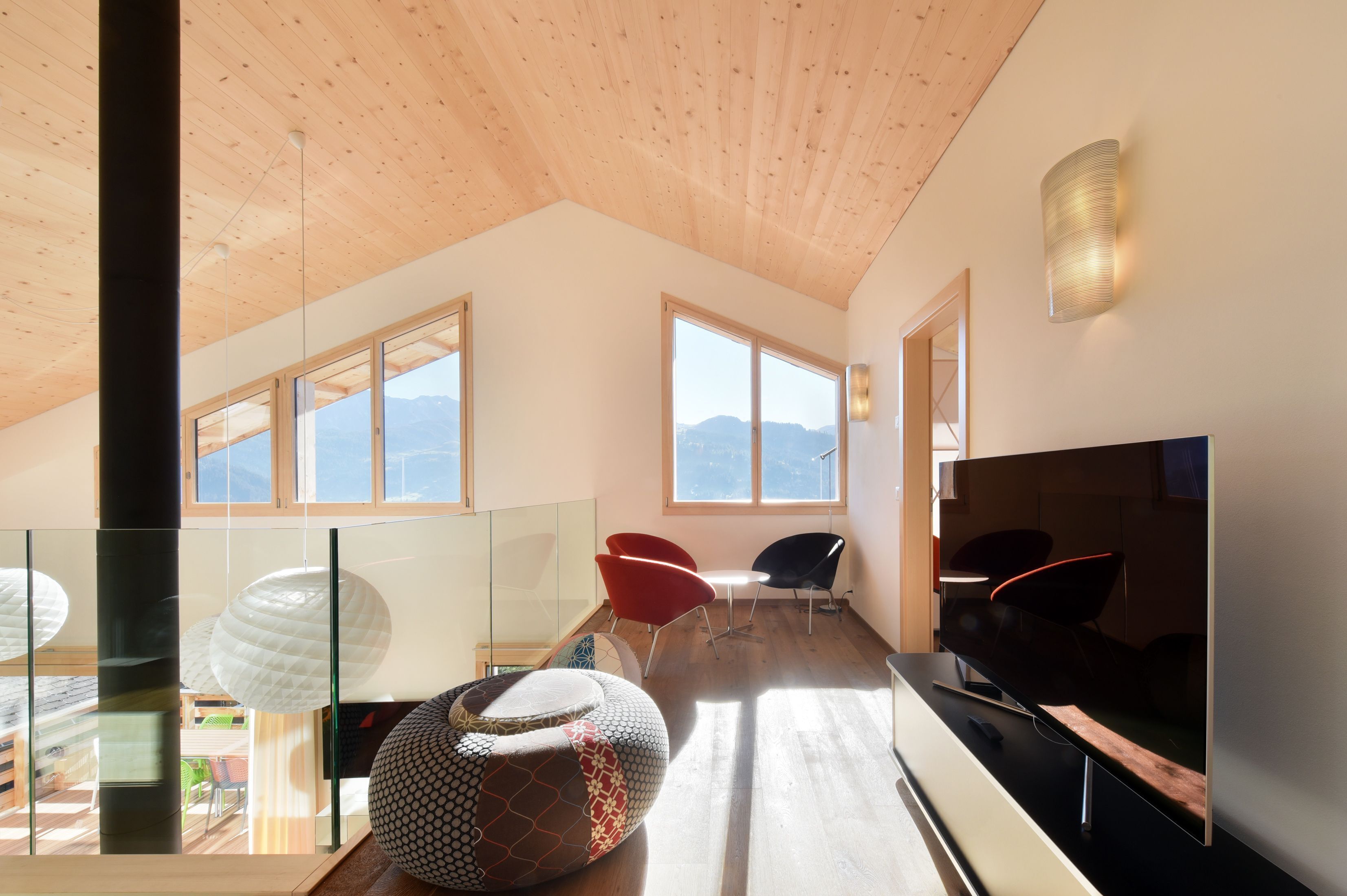Une pièce spacieuse avec un plafond haut, de grandes fenêtres et un aménagement intérieur moderne.