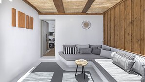 Una sala de estar moderna con techo de madera, un sofá seccional gris y una pequeña mesa de madera.