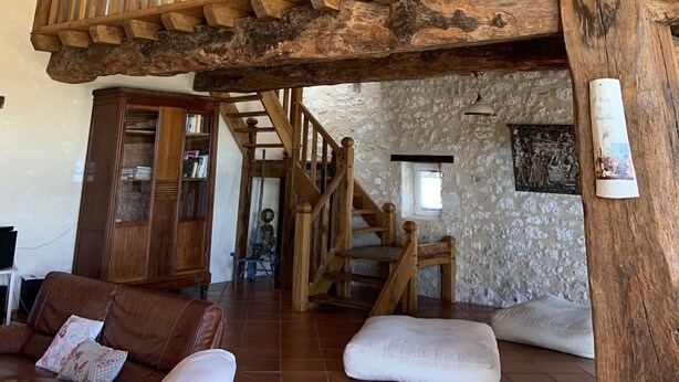 Ein geräumiger Wohnbereich mit einer Holztreppe und einer Erschliessung/Galerie.