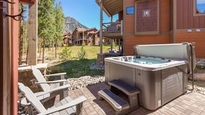 A hot tub and outdoor seating area with a view of a mountain and a building with balconies. - Near Keystone Village, Private Balcony & Large Windows with Mountain Views (Keystone)
