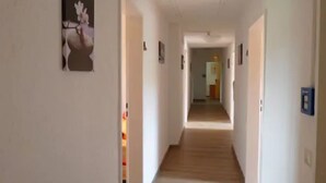 A narrow, well-lit hallway with a wooden floor leading to a room. - Herberge zur Herrlichkeit (Dorsten)