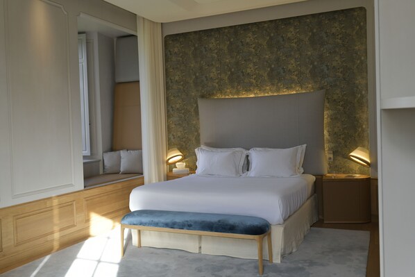 A modern bedroom with a large bed, bedside lamps, and a bench. - Château de Ferrand (Saint-Hippolyte)