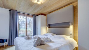 Een hotelkamer met een groot bed, een nachtkastje en uitzicht op het omliggende landschap.