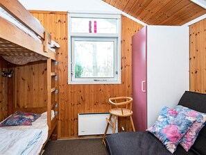 A compact room with a bunk bed, a small desk, and a chair. - 4 Star Holiday Home in Juelsminde (Horsens)