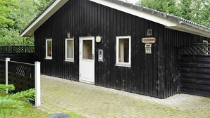 A black wooden building with a white door and two windows, labeled "Lillebo 75". - 4 Person Holiday Home in Ansager (Ansager)