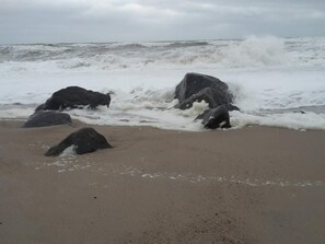 A beach with large rocks and rough waves.