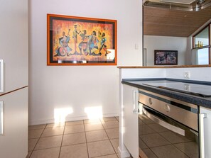 A modern kitchen with a countertop, cabinets, and a tiled floor.