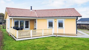 A single-story house with a red-tiled roof, a covered porch, and a grassy yard. - 8 Person Holiday Home in Vestervig-by Traum (Vestervig)