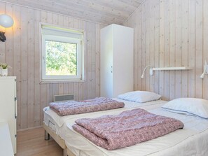 A bedroom with two beds, a window, a wardrobe, and a bedside lamp. - Serene Holiday Home in Juelsminde near Beach (Juelsminde)