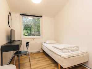 A small, single-room accommodation with a bed, a desk, a chair, and a radiator. - 4 Star Holiday Home in Oster Assels (Øster Assels)