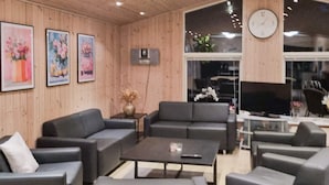 Een moderne woonkamer met banken, een salontafel en kunstwerken aan de wanden.
