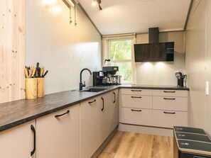 A compact kitchen with a sink, a coffee maker, and a window. - 4 Star Holiday Home in Oster Assels (Øster Assels)