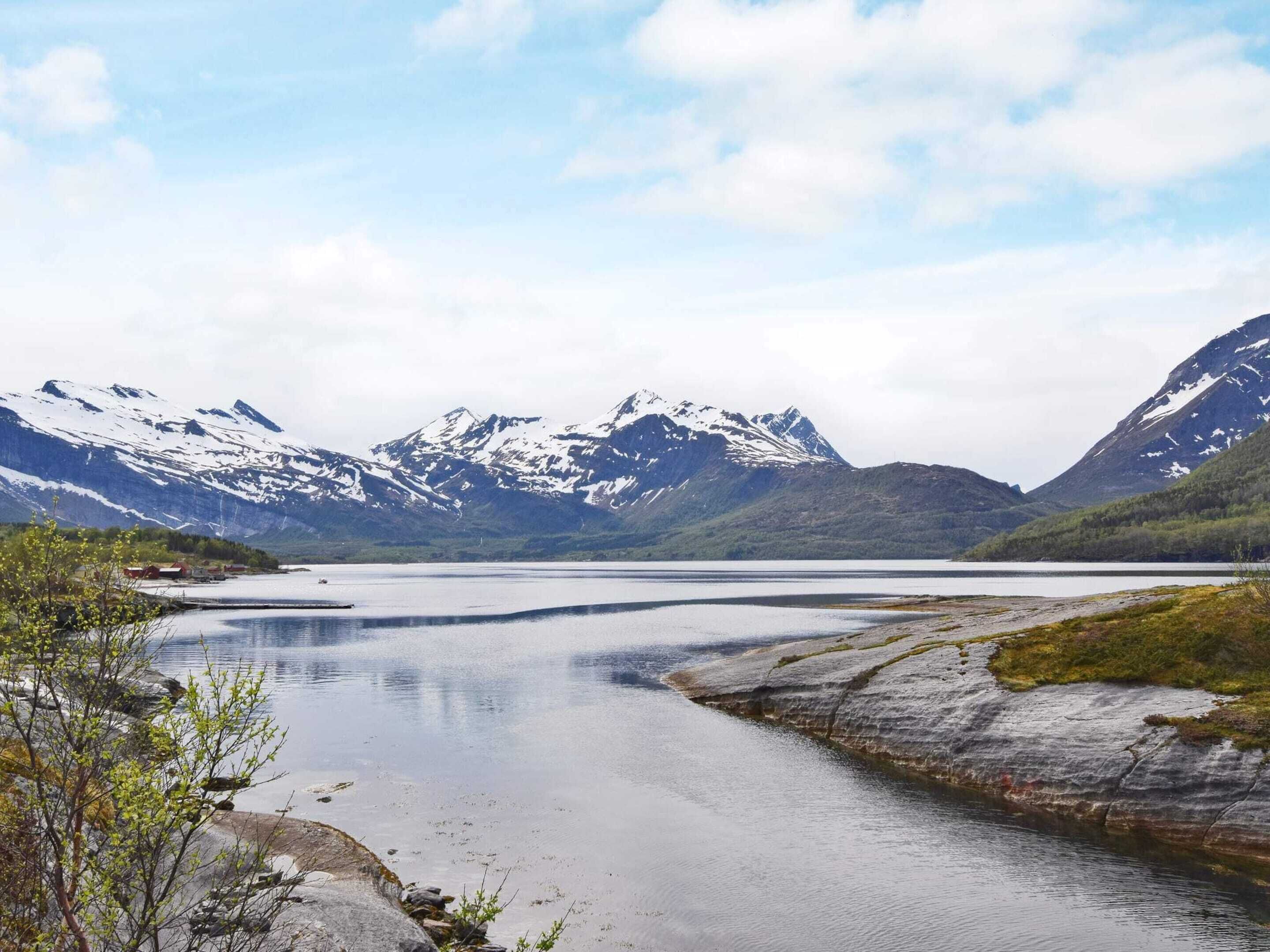 A calm lake with mountains in the background.