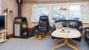 A cozy living room with a fireplace, leather furniture, and a television.
