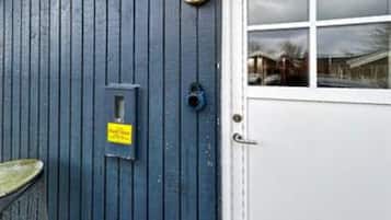Una porta blu con un cartello giallo, una finestra e una maniglia di metallo.