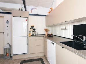 A modern kitchen with a refrigerator, coffee maker, sink, and decorative items. - Captivating Holiday Home in Ulfborg near Sea (Ulfborg)