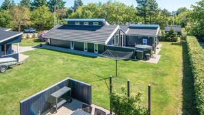 A modern house with a large patio, a garage, and a swimming pool. - Captivating Holiday Home in Ulfborg near Sea (Ulfborg)