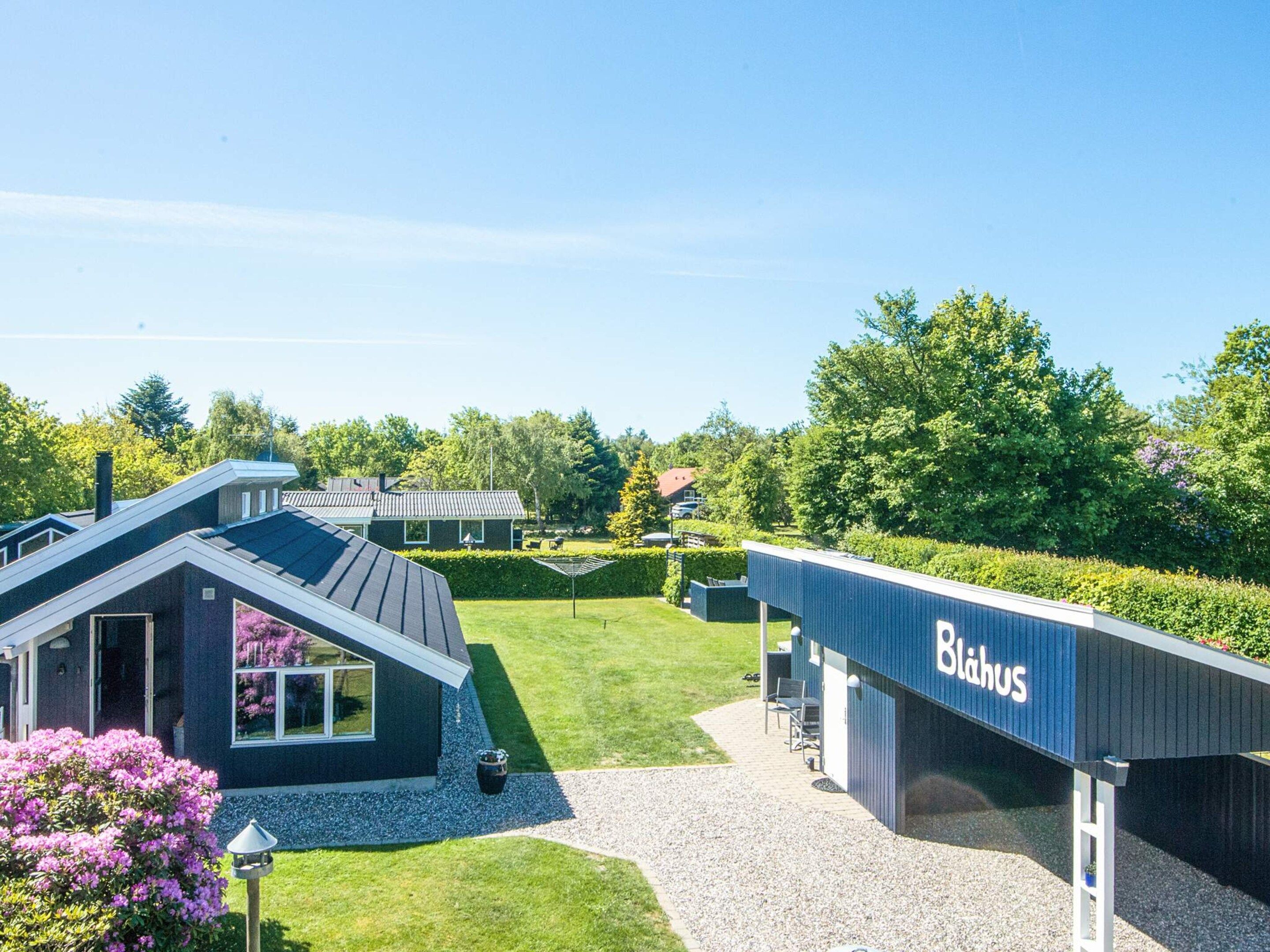A modern building with a sign reading 'Blahus' and a well-maintained lawn.