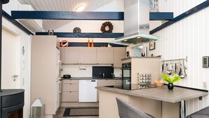 A modern kitchen with a central island, built-in appliances, and a fireplace. - Captivating Holiday Home in Ulfborg near Sea (Ulfborg)