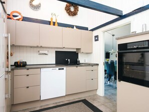 A modern kitchen with a dishwasher, oven, and a black countertop. - Captivating Holiday Home in Ulfborg near Sea (Ulfborg)